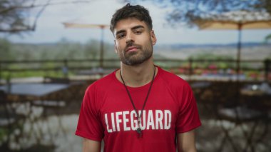 Kırmızı tişörtlü ve düdüklü cankurtaran restoran terasında öpüşüyor..