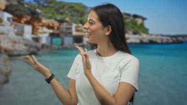Avuç içleri açık gülümseyen ve stüdyo sahili manzaralı bir kadın. Keyif yaz seyahati..