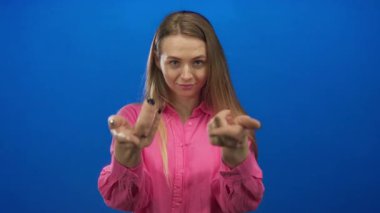 Ayrı bir mavi arka plan üzerinde güven içinde el kol hareketi yapan, parlak pembe bir gömlek giyen, açık kolları ve dostça bir ifadeyle davet ya da hoş geldin diyen bir kadın..