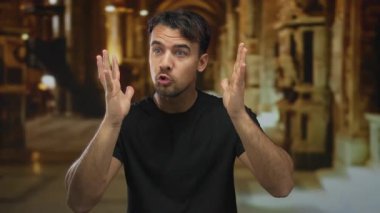 Kilise ortamında konuşurken duygularını ifade eden genç İspanyol bir adam, hareketli bir iletişim ve nişan anını yakalıyor..