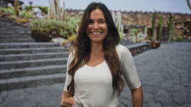 Kadın kamerayı işaret eder ve taş sokak basamaklarında çıplak elle yumruk pompası yapar; güven zaferi.