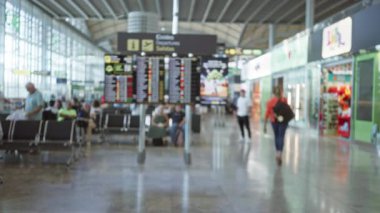 Havaalanı terminali Bokeh arkaplanını bulanıklaştırdı. Odaklanmamış çıkış tahtası, oturma sıraları ve depolama öngörüleri istasyon salonunda; arka plan arka plan telif alanı şablonu.