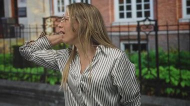 Bir kadın binanın önünde dikilirken bağırıyor