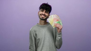 Gülümseyen adam Norveç kronu banknotlarını mor arka planda tutarak modern İskandinav ortamında zenginliği ve refahı sembolize ediyor..