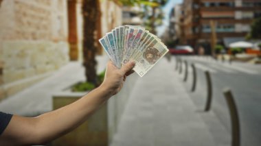 Elinde Polonyalı banknotlar tutan bir adam, bir şehir caddesinde kolları açıkta gezen, şehir ortamında para gösteren bir adam..