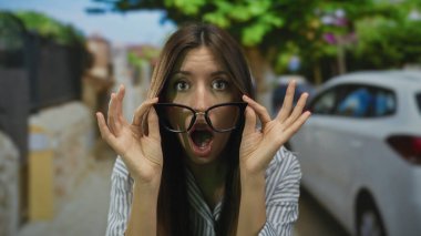 Kadın, güneşli bir şehir sokağında dikilirken büyük bardakları açık ağızla kaldırıyor. Sürpriz şok..