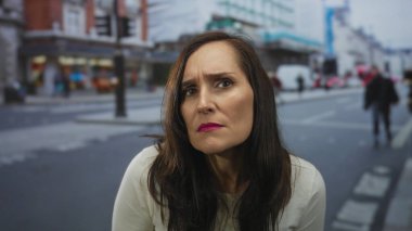 Genç İspanyol kadın kaşlarını kaldırdı ve kalabalık şehir caddesinde yaya geçidinde öne doğru eğildi..