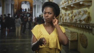 Kadın mermer büstler ve kalabalık koridor ile dekoratif müze binası içerisindeki izleyiciyi işaret ediyor..