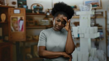 Sessiz bir odada endişeli görünen bir kadın. Raflar düşünceli bir ortam izlenimi veriyor. Düşünceli bir iç mekan ortamında duygu ve iç gözlem sergiliyor.