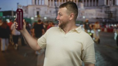 Büyük bir şişe tutan ve gülümseyen bir adam meşgul bir şehir caddesinde onu yükseltmek; mutlu sağlıklı ferahlatıcı.