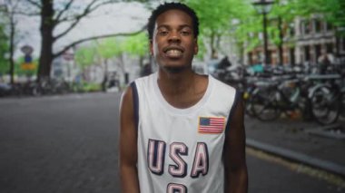Erkek parmağı, bisiklet parkının yanındaki sokakta bayrak yamasıyla ABD formasını işaret ediyor..