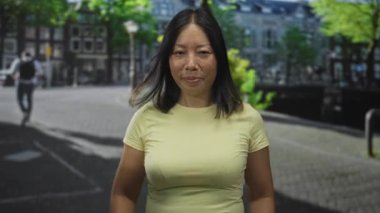 Elleri açık ve görünür avuçları olan bir kadın, bir şehir caddesinde hoş geldin jesti ile kollarını kaldırdı; açıklık.