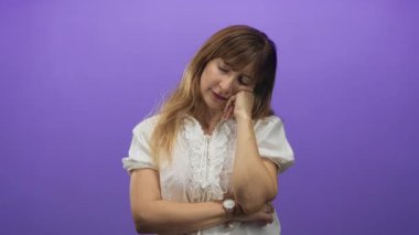 Stüdyoda mor bir duvara karşı el ele ve kapalı gözler ile dinlenen kadın; yorgun tefekkür.