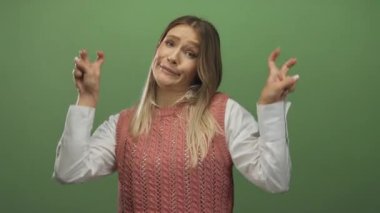 Genç sarışın kadın alaycı bir ifade takınıyor ve parlak yeşil bir geçmişe karşı jest yapıyor. İroni ya da şüpheciliği mizahi bir şekilde aktarıyor.