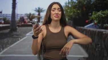 Akıllı telefon tutan kadın şaşırmış görünüyor.