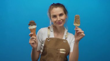 Kahverengi bir önlük giymiş, elinde dondurmayla gülümseyen bir kadın, neşeli yüz ifadesini ve tatlı ikramlara olan aşkını vurguluyor..