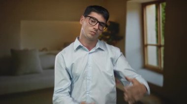 Genç İspanyol adam, çağdaş bir bina odasında mola vermek için iki elini kaldırır..