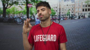 Kırmızı cankurtaran tişörtlü İspanyol genç adam park halindeki bisikletlerle dolu işlek kaldırım taşı caddesinde avuç içi kadar açık sunar; belirsizlik.