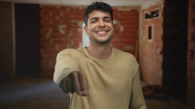 İnşaat alanında inşaat işçisi erkek işçiyi karşılamak için yumruk tokuşturuyor..