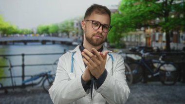 Beyaz önlüklü genç doktor, Amsterdam 'da sokakta el çırpıyor. Şefkat umuyoruz..
