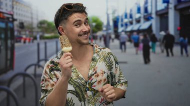 Canlı bir şehir caddesini gezerken dondurmanın keyfini çıkaran genç İspanyol adam, keyifli bir seyahat ve açık hava keyfi ruhunu yakalıyor..