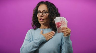 Icelandic Krona 'nın banknotlarını elinde tutan kadın canlı mor bir geçmişe sahip, finansal bağlılığı ya da vaadi simgeliyor.