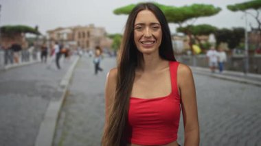 Parke taşlı bir sokakta el ele ve çıplak omuz omuza gülümseyen bir kadın. Mutluluk, kendine güven, rahatlık..