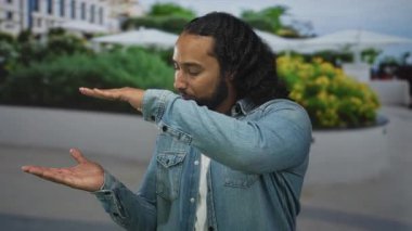 Erkek, tohum ve şemsiyeler arasında sokakta avuç içi ile ayrı el ele tutuşur; sakin konsantrasyon dengesi.