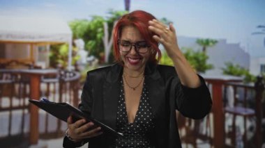 Restoran terasında elinde pano olan bir kadın, notlara yazarak gülümsüyor, utanç verici küçük bir hata..