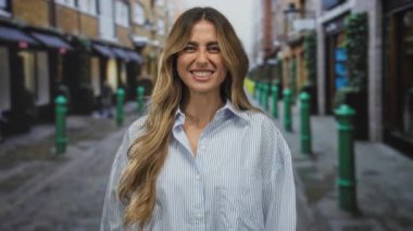 Genç sarışın kadın iki eliyle başını tutuyor ve dar bir sokak arasında gözlerini sıkıyor; stres gerginliği sıkıntısı.