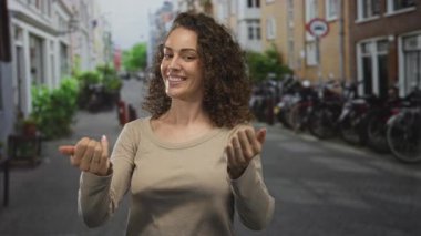 Kadın parmakla gösterip, park halindeki bisiklet ve tuğla binalarla dolu dar bir caddede el ele tutuşuyor..