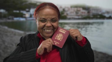 Afrikalı Amerikalı kadınlar, gülen yüz gösteren binanın yanında İspanyol pasaportu taşıyorlar. Gurur seyahati neşeyi güçlendiriyor..