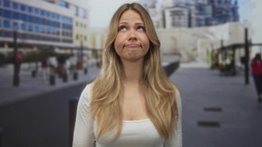 Marsilya caddesinde modern binaların ve kalın binaların yakınındaki el hareketlerini silkeleyen çıplak bir kadın..