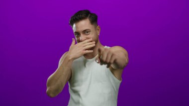 Sakallı genç adam soyutlanmış mor bir arka plana bakıp gülüyor beyaz bir gömlek giyiyor ve neşeli ve kaygısız bir tavır sergiliyor..