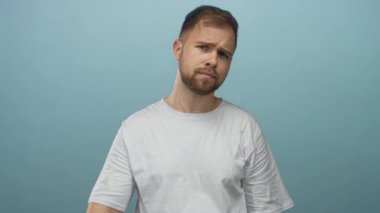 Açık elli bir adam stüdyoda açık mavi duvara karşı duruş hareketi sergiliyor..