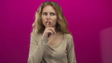 Kadın parmaklarıyla Stüdyo sarışın dudaklar Pembe jest sessiz poster sessiz gizemi çağrıştırıyor.