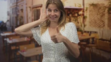 Göğüs göğüse bir kadın ve bir teras restoranının yemek alanında gülümseyerek ve dinleyerek, neşeli merak onayı.