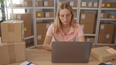 Dizüstü bilgisayarı ve kutuları olan kadın bir depolama binasında zafer için kollarını kaldırdı; küçük işletme başarısı neşe.