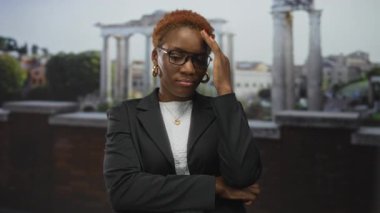 Genç Afrikalı kadın sadece Roma harabelerinin ortasında antik taş binada alnını tutuyor..