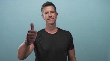 Deniz mavisi atölyesinde el ve baş parmağıyla baş parmak kaldıran adam; onay desteği desteği desteği desteği teşvik.