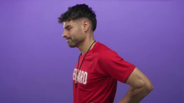 Kırmızı tişört giyen cankurtaran stüdyo görüntüsünde sırt ağrısı için sırtı aşağıda tutan ıslık çalan cankurtaran..