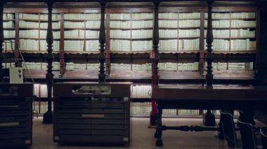 Eski kütüphane rafları ve ahşap ekran tabloları hafifçe çıkarılmış iç mekan; arka plan arka plan telif alanı sakinliği.