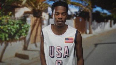 Güneşli şehir caddesinde sessizlik için parmaklar dudaklara bulanık binaların ve yeşilliklerin yanında sessizlik..