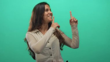 Stüdyoda gülümseyen ve işaret parmağı yukarı doğru olan bir kadın, iyimserlik keşfi.