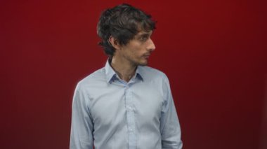 Kırmızı stüdyo duvarına karşı ağzı açık bir adam jest, portre tarzı baş yana dönük; şaşkınlık.