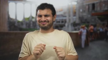 İspanyol adam, güneş ışığı altındaki antik Roma binasında parlak günışığı altındaki taş sütunlarla el sıkışıyor..