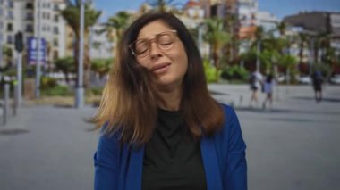 Mavi ceketli ve gözlüklü İspanyol kadın sokağın ortasında somurturken kaşlarını çatıyor. Hayal kırıklığı stresi çileden çıkarıyor..