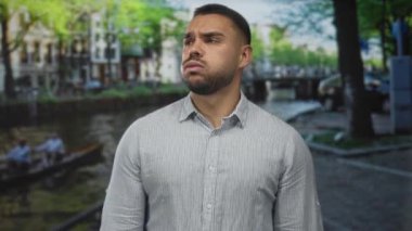 Elleri yanaklarına bastırılmış çizgili tişört giyen ve kanal sokak kapalı gözler; tefekkür.