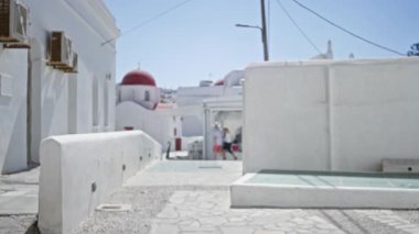 Beyaz yıkanmış binalar ve kırmızı kilise kubbeleri ile Mykonos caddesi, Odaklanamayan bokeh arkaplan; arka plan arka plan telif alanı sakin.
