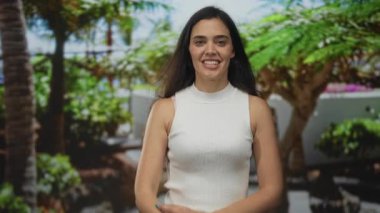 Kadın, orman parkında yukarı doğru parmağını gösterir kolsuz üst ve çıplak el görünür; merak dinginliği.